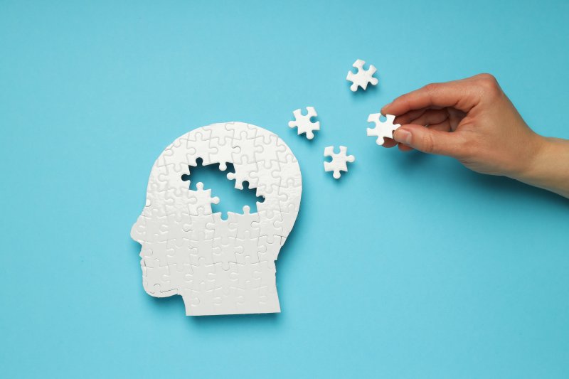 A puzzle head with missing elements against a blue background